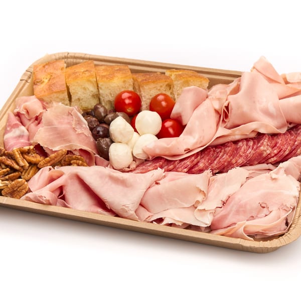 A charcuterie board with various meats, cheeses, olives, tomatoes, pecans, and focaccia bread.