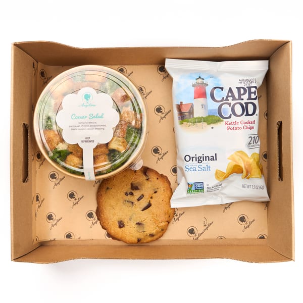 Boxed lunch with a Caesar salad, chocolate chip cookie, and Cape Cod chips in an Angelina box.