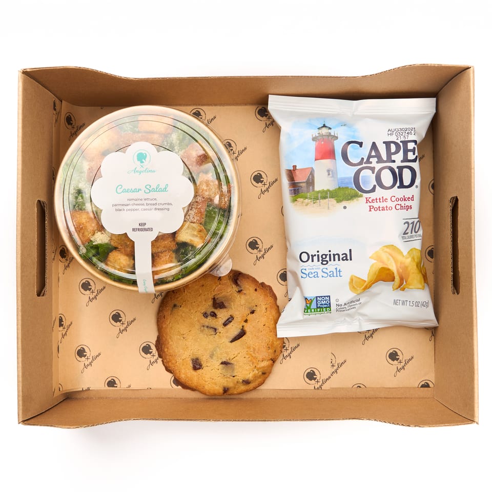 Boxed lunch with a Caesar salad, chocolate chip cookie, and Cape Cod chips in an Angelina box.