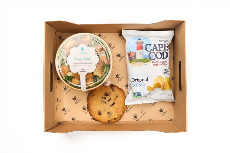 Boxed lunch with a Caesar salad, chocolate chip cookie, and Cape Cod chips in an Angelina box.