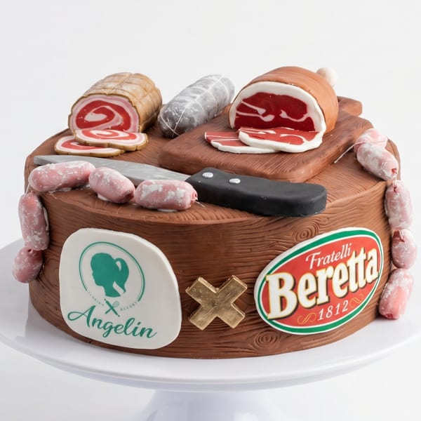 A cake designed to look like a charcuterie board with various meats, a knife, and brand logos.