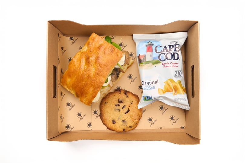 Boxed lunch with a focaccia sandwich, chocolate chip cookie, and Cape Cod chips in an Angelina box.