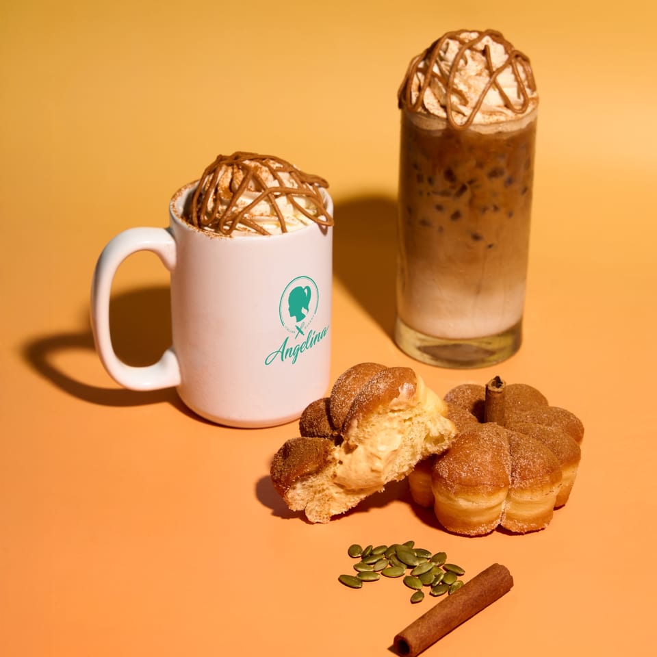 Pumpkin spice latte, iced coffee, and pumpkin-shaped pastries with pumpkin seeds and cinnamon stick.